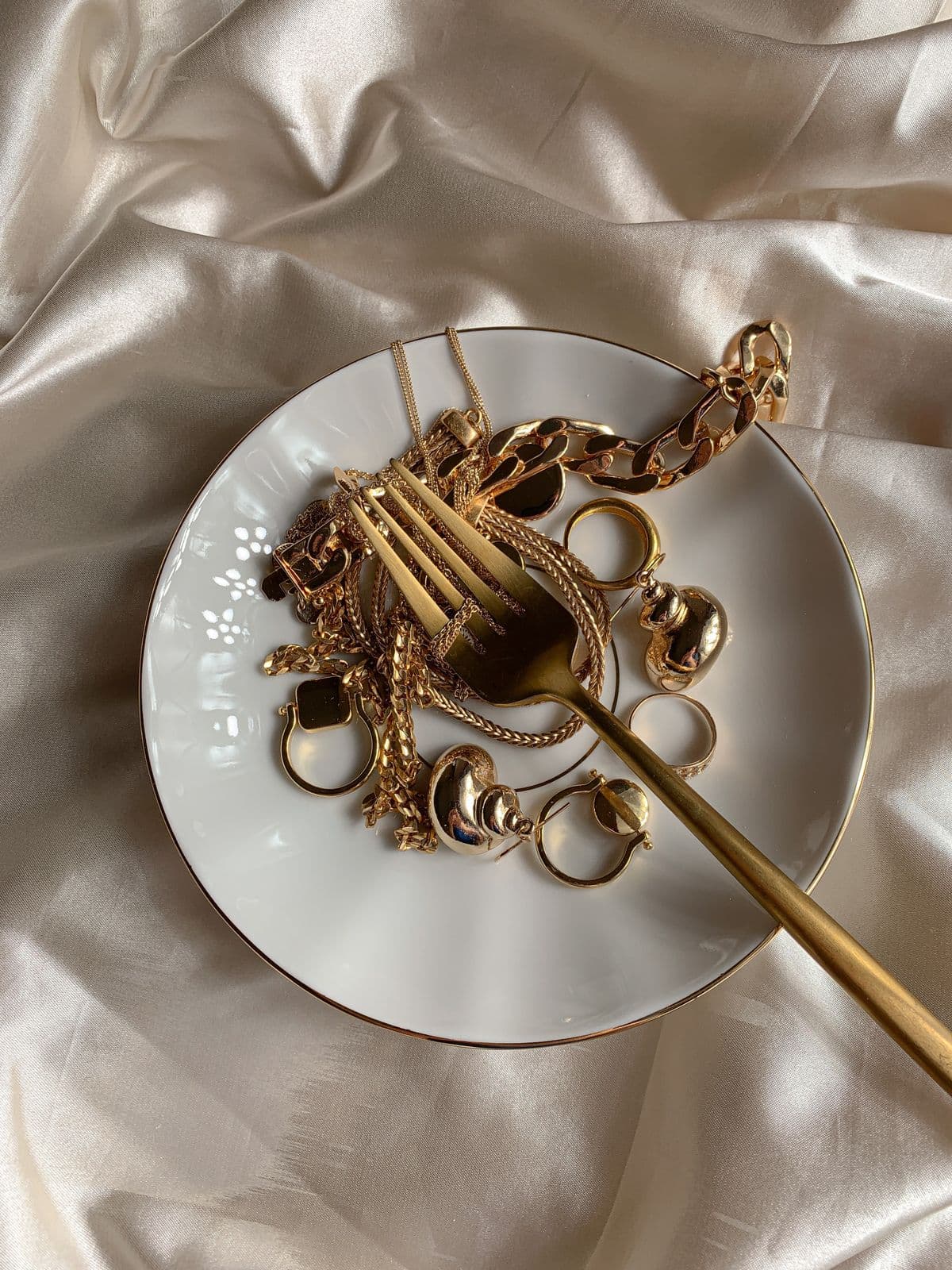 Gold jewelry on a silk-draped atelier table